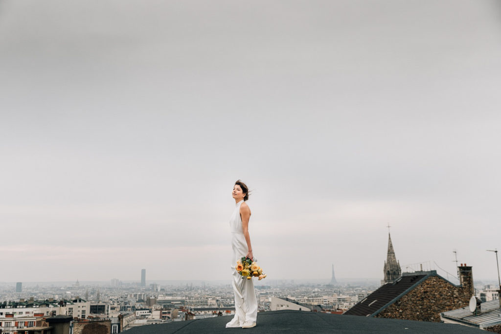une mariée sur la terrasse du Solaris avec vue sur les toits de Paris - Pierre Atelier