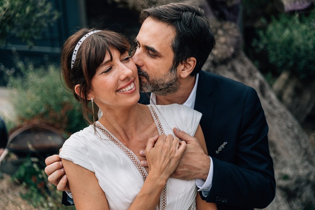 Baiser mariés cocktail Village de Sully oliviers — Pierre Atelier photographe mariage Yvelines