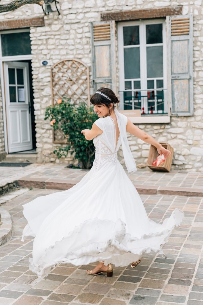 Mariée robe bohème tourne façade pierre Village de Sully — Pierre Atelier photographe Yvelines